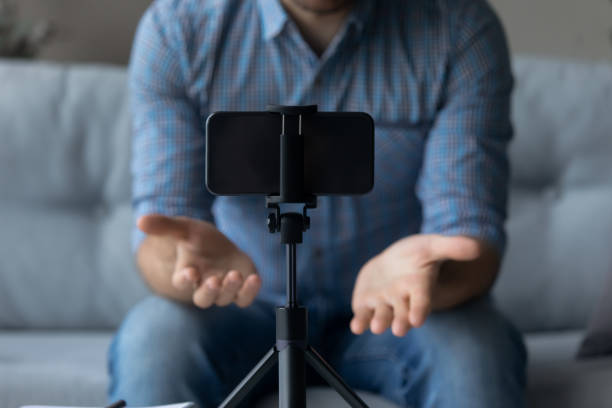 istock Crop close up man recording video, using smartphone on tripod 1372744120