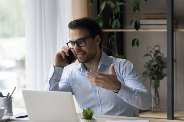 istock Smiling businessman in glasses talking on phone, enjoying conversation 1372744149