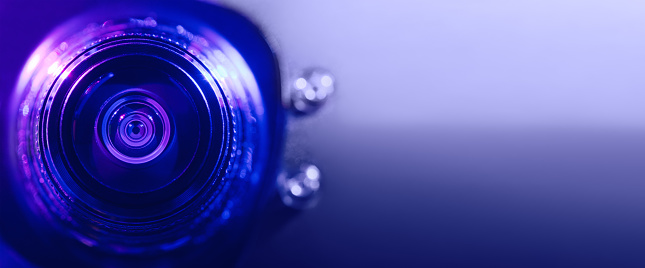 .Camera lens with purple and blue backlight. Banner
