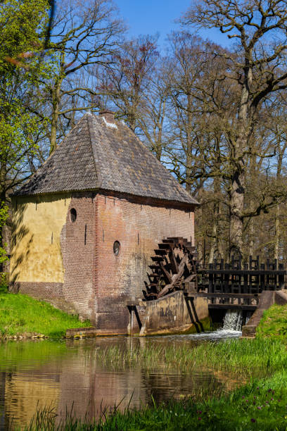 Vorden, The Netherlands - April 26, 2021: Watermill in park Hackfort in Vorden Gelderland in The Netherlands famous for his beautiful wild flowers