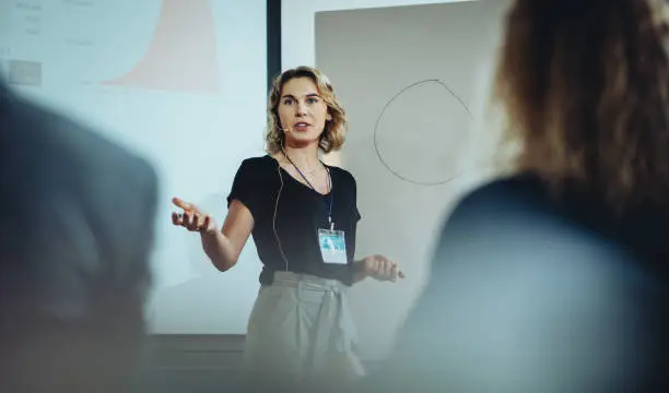 Woman presenting her idea to colleagues in meeting. Businesswoman public speaking in a conference meeting.