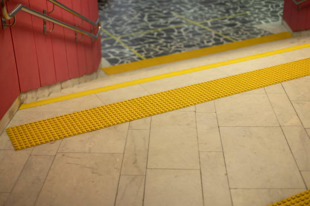 Surface for visually impaired. Yellow limiter for blind. Markings on stairs. Steps in building. Infrastructure for people with disabilities.