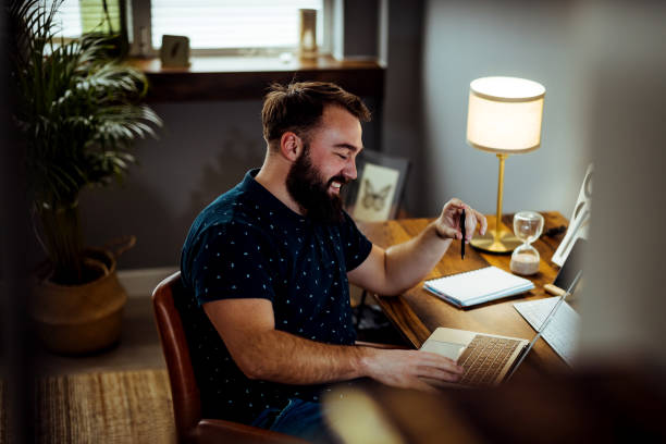 istock Handsome Specialist Working on Laptop Computer in Creative Home Living Room 1372747090
