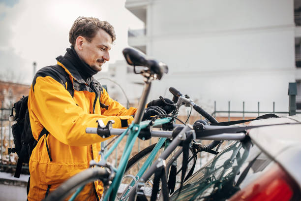 taking bicycle of the rack - fietsenrek fotos stockfoto's en -beelden
