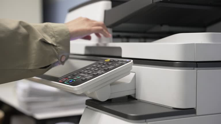 Hand of woman is using a photocopier to copy documents.