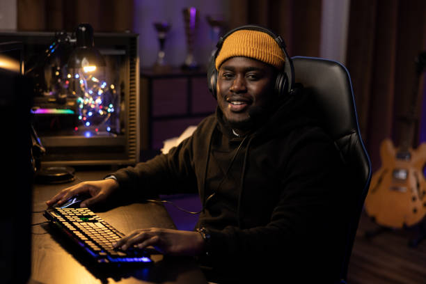 istock A man wearing headphones spends time in front of a computer in a dark room. A computer set illuminated with led colors. Professional gamer's equipment playing at night 1372751681