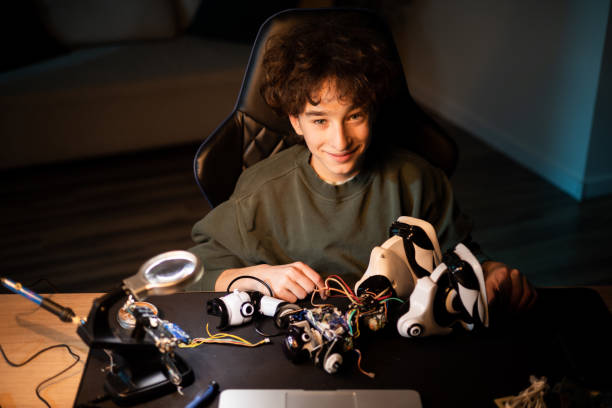 istock Smiling boy repairs, constructs toy, solders cables, colors wires, smart student develops passion for robotics, electronics 1372751930