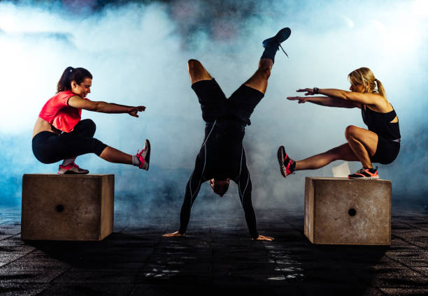 gym class jumping on wooden boxes guided by trainer