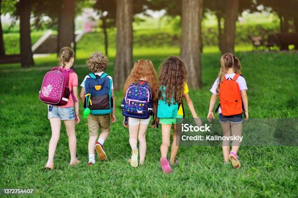 Group Of Children With School Backpacks Walking Hand In Hand Holidays Back To School Summer Camp Stock Photo - Download Image Now