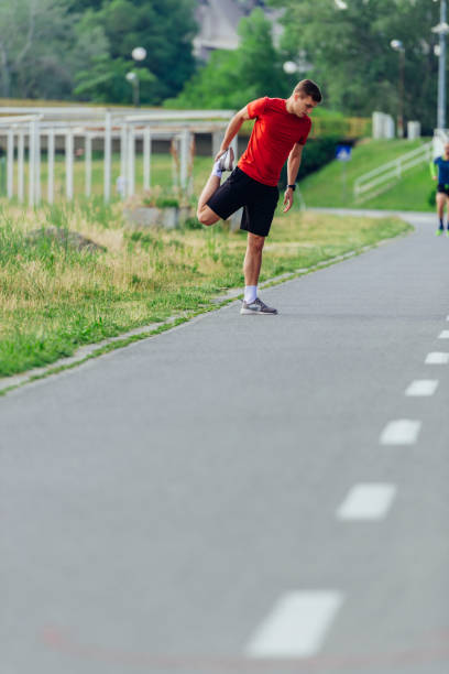 istock Handsome young man stretching and warming up before for morning workout  in the park 1372755981