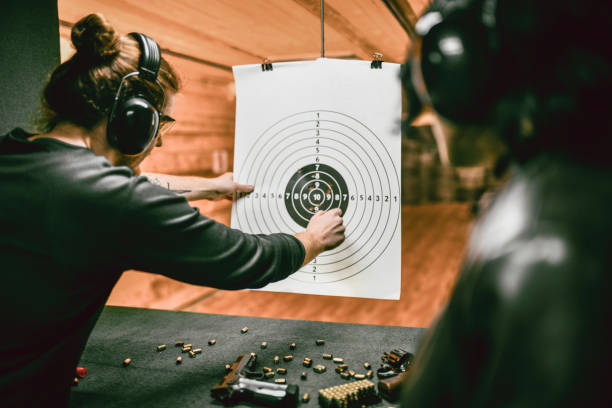 istock Firearms Instructor Marking Female Shooter's Results On Gun Range 1372757341