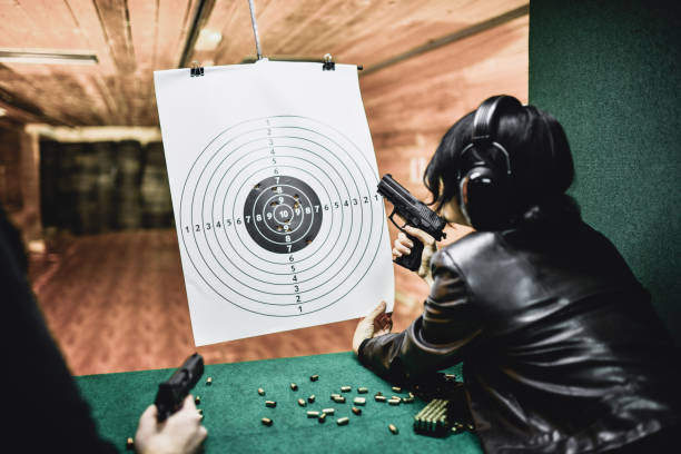 istock Female Examining Test Results With Instructor During Firearms Training 1372758130