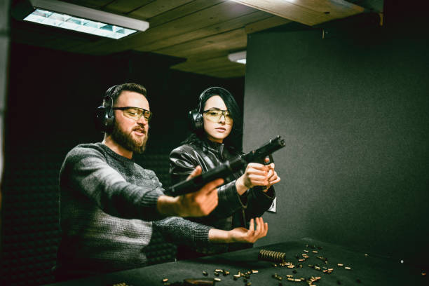istock Male Showing Female Student Proper Gun Loading And Gripping Technique 1372758191