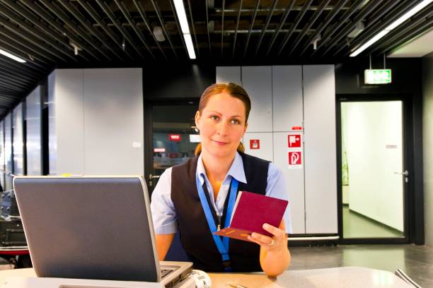 giovane dipendente di una compagnia aerea al banco del check-in - security staff security airport airport security foto e immagini stock