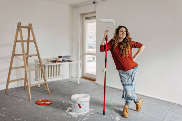 young pregnant woman painting nursery room - repairing apartment home improvement painting imagens e fotografias de stock