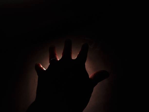 istock hand man in the dark on the light 1372762547