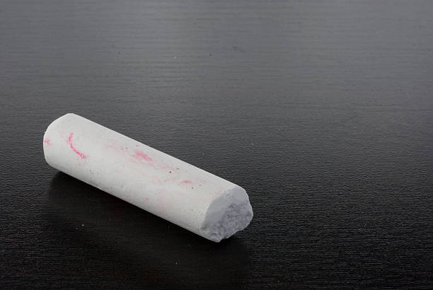 istock A single piece of white chalk with pink marks on black 137276264