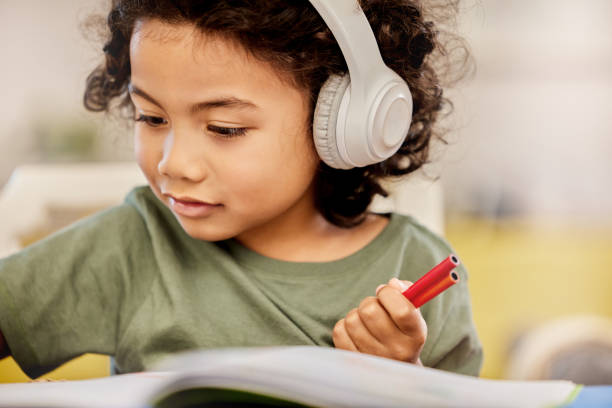 Shot of a little boy drawing while listening to music at home Focused on drawing the perfect picture vehicle interior audio stock pictures, royalty-free photos & images