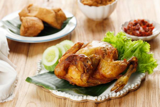 istock Deep Fried Whole Fried Chicken, Served with Cucumber, vegetable, and Sambal. 1372769250