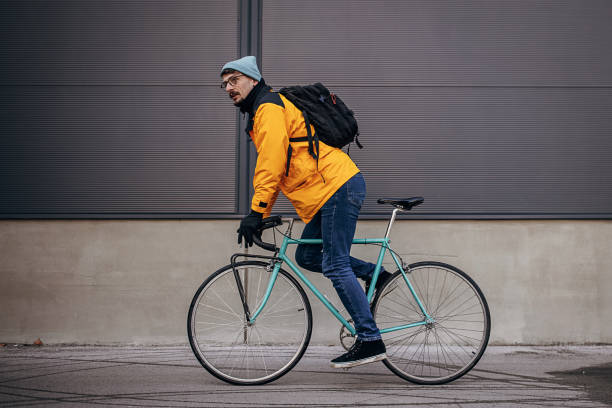 One man, male riding his bicycle in the city street on a winter day.