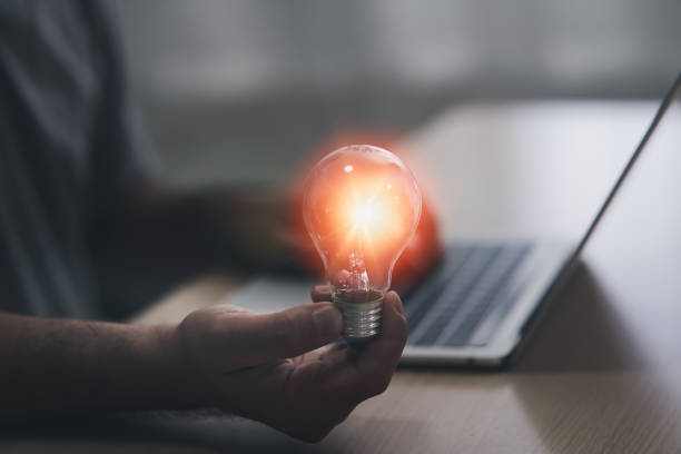 istock Hand of man with a light bulb And there is a gear icon in it And he is using a notebook computer. The idea of ​​inspiration from online technology.innovation idea concept. 1372772563