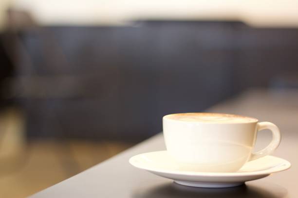 istock Hot coffee cup on long flat black color table indoor with empty copy space for text or qoute background usage 1372772720