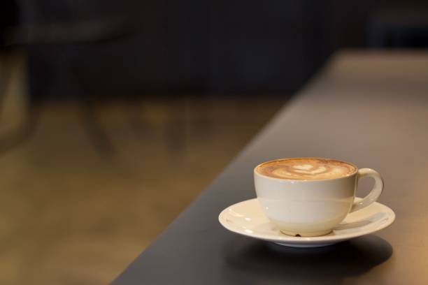istock Hot coffee cup on long flat black color table indoor with empty copy space for text or qoute background usage 1372772749