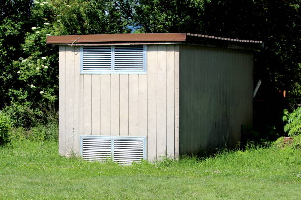 istock Concrete local electricity substation building with two ventilation openings covered with metal roof next to local forest 1372777774
