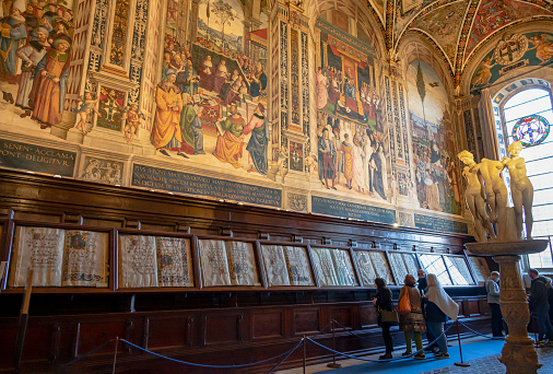 November 20, 2021 - Siena, Italy - Beautifully frescoed, the Piccolomini Library in the Siena Cathedral displays illuminated music scores and a statue of the Three Graces.