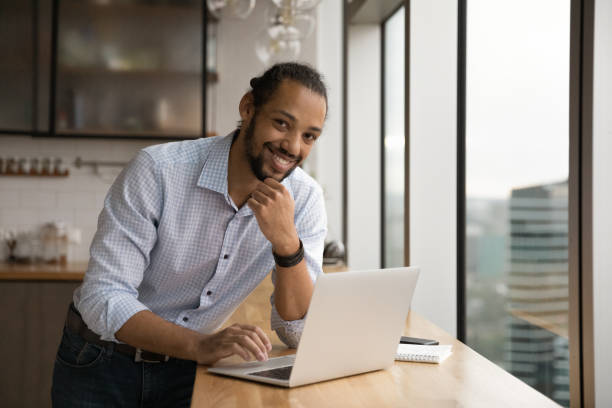 istock African businessman lean at table with computer look at camera 1372785529