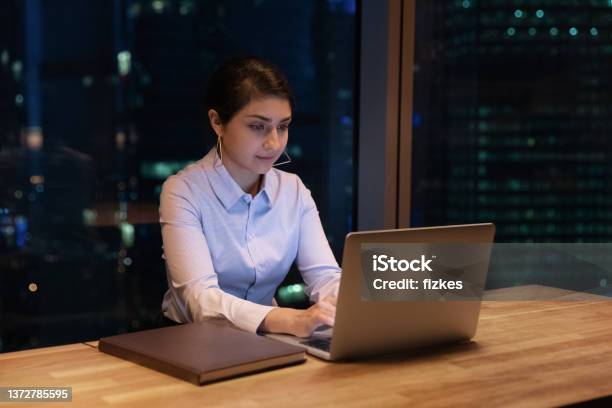 Indian Woman Texting On Computer Working Until Late In Office Stock Photo - Download Image Now