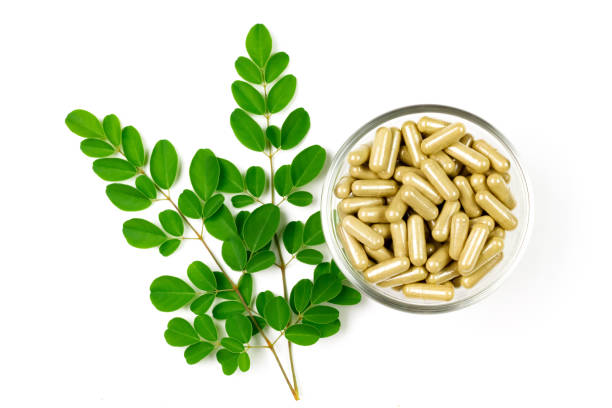 istock Moringa oleifera capsule on glass bowl with moringa leaf isolated on white background. 1372786342