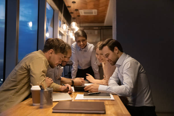 istock Diverse employees gathered in office use smartphone watching funny video 1372788122