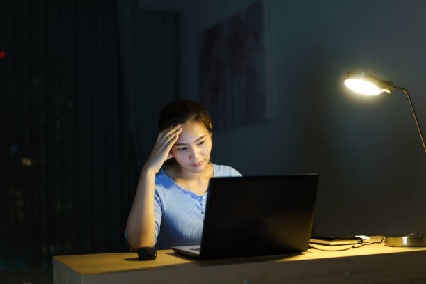 istock Asian woman work late at night stressful with project research problems on a laptop computer or notebook at home office  burnout syndrome concept. 1372790353