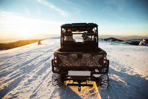 Friends drive atv on snow off road