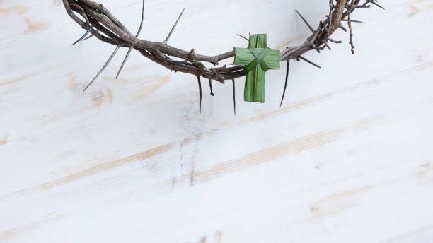 istock Palm cross on crown of thorns on white 1372791567