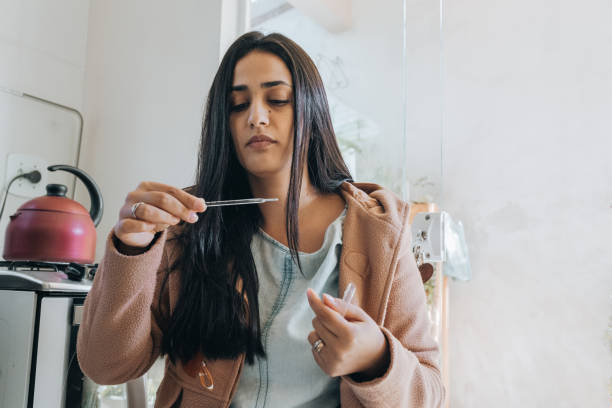 istock Woman looking at temperature on thermometer 1372792450