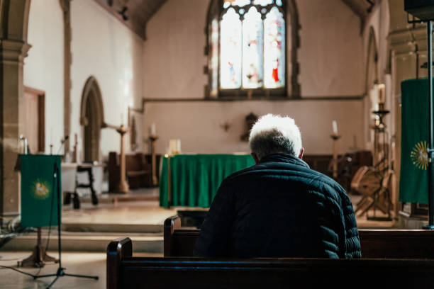 istock Senior man praying in church 1372794315