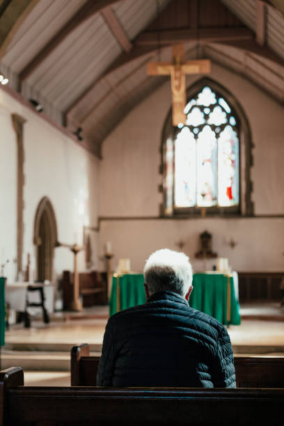 istock Senior man praying in church 1372794337