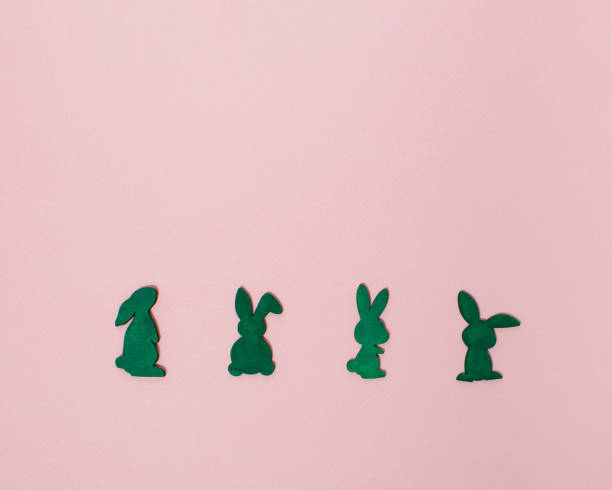 istock Rabbits lined up horizontally on pastel pink background with copy space. Minimal easter concept with bunnies. Flat lay easter season. 1372796176