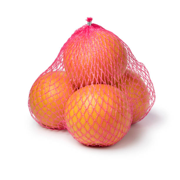 istock Fresh ripe red grapefruit in a pink net on white background 1372797681