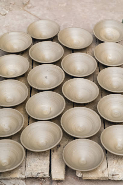 Many earthen pots or clay pots are kept for drying in the sun in the workshop.