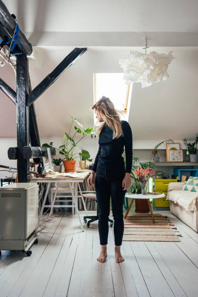 istock An Anonymous Casually Dressed Blonde Standing Barefoot In Her Living Room And Relaxing 1372799362