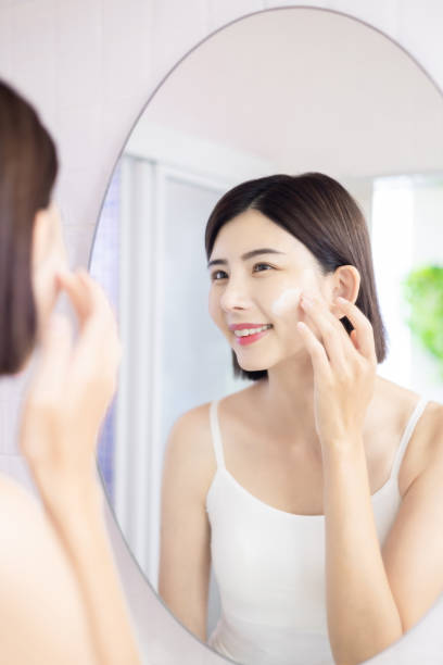 istock woman apply cream on face 1372801091