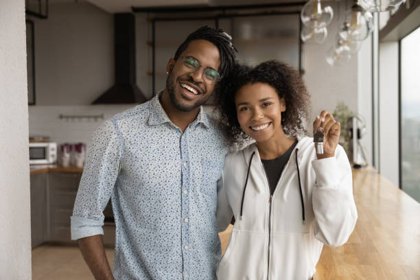 glückliches junges afroamerikanisches familienpaar zeigt schlüssel. - family african ethnicity black african descent stock-fotos und bilder