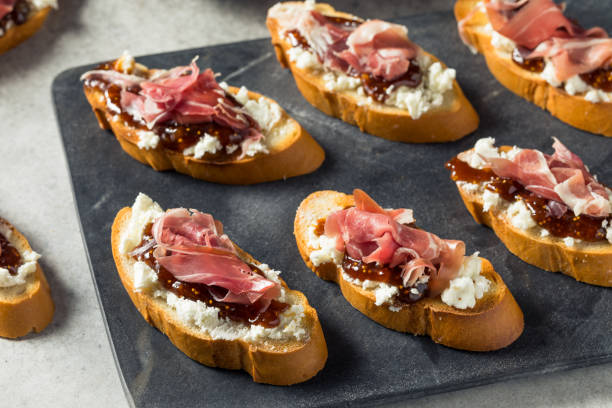 Homemade Prosciutto Goat Cheese Toast Homemade Prosciutto Goat Cheese Toast with Fig Jam prosciutto stock pictures, royalty-free photos & images