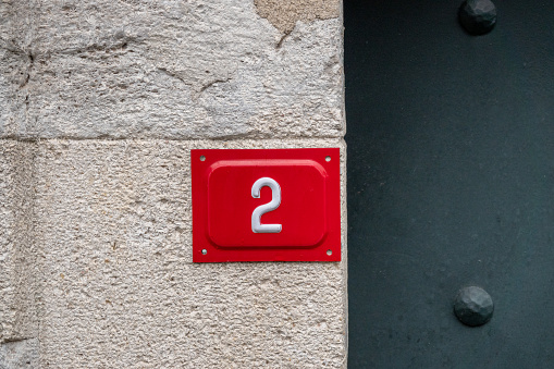 house number twenty-five - old rusty 25 plaque mounted on timber frame building