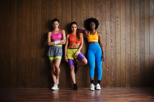 Portrait shot of three handsome young women before their workout in the fitness studio