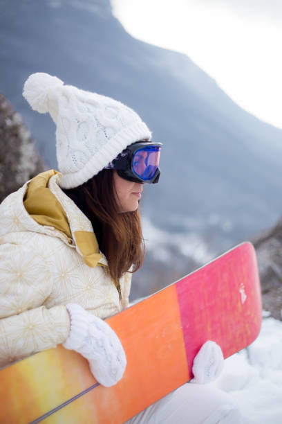 istock Young woman with snowboard in sunlight 1372807902