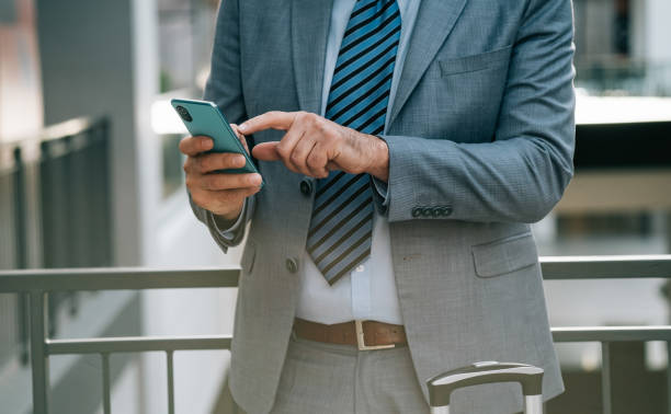 istock An Anonymous Businessman Using his Mobile Phone at the Airport 1372809106